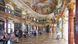 People sit as they observe the details of an ornate fresco in the library hall of Wiblingen monastery, Ulm. 