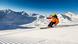 A lone skier on a high snow covered mountain range.