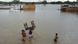 Una familia cruza una calle inundada por las fuertes lluvias en Chiclayo, Perú (Archivo: 12.03.2023)