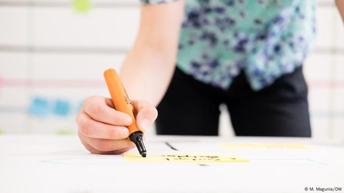 Person writing with marker on flashcard